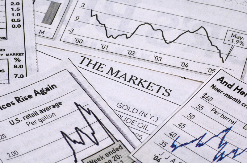 image of newspapers with the markets graphs and charts 